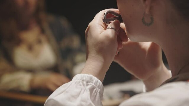 A young woman playing jaw harp in the circle of musicians