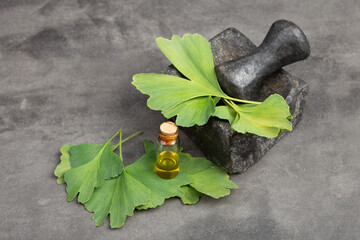 Bottle of pills, essential oil and ginkgo leaves on grey. Traditional, herbal medicine and Homeopathy concept. - 638805161