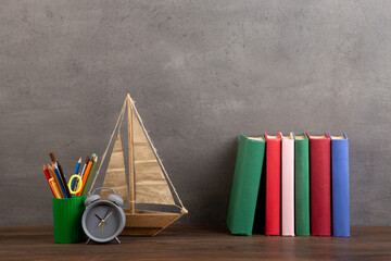 Education is a journey concept, toy boat and books on the wooden table, inspiration for a writing a fairy tale. Elementary school supplies - 638806101