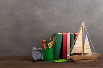 Education is a journey concept, toy boat and books on the wooden table, inspiration for a writing a fairy tale. Elementary school supplies - 638806143