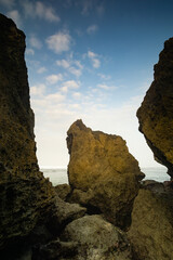 lanscape views of indrayanti beach yogyakarta gunungkidul indonesia  cliffs and rocks on the seafront with beautiful clouds at sunrise or sunset