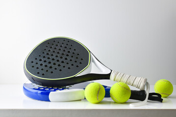 Two blue and black paddle rackets balls on white table