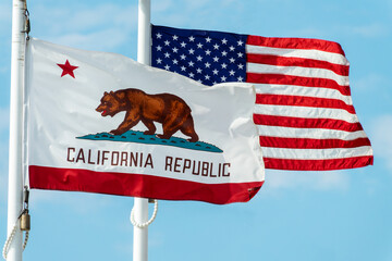 California Republic bear flag and US american flags floating on poles side by side