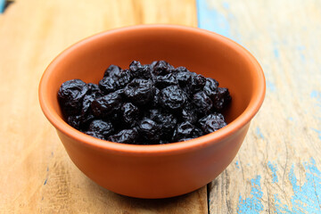 Dried Blueberry in a bowl on wooden background 