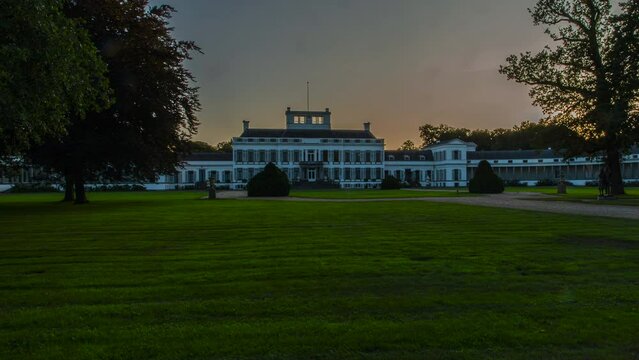 Beautiful time lapse of the sun setting behind a imposing palace in the Netherlands