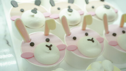 Cupcakes with very cute cartoon animal characters are displayed in a display case at a bakery or cake shop pastry. Child's favorite food and snacks.