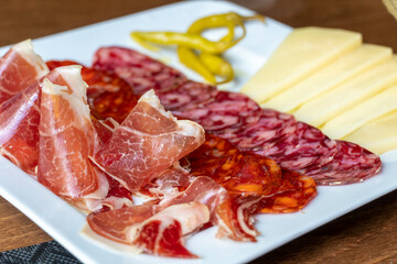 Plate with sausages chorizo salchichon manchego cheese and serrano ham Spanish appetizer