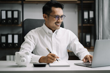 Businessmen asian hold credit cards, conduct financial transactions via laptop and take note of information in the morning.