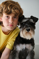 Boy with adorable purebred dog on light background