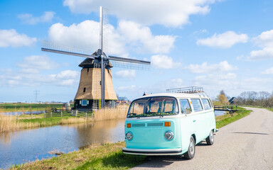 road trip with an old vintage car in the Dutch flower bulb region with tulip fields during Spring...