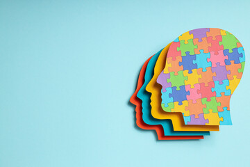 Paper human heads with colorful puzzle pieces on a light background, place for text. World autism day concept - Powered by Adobe