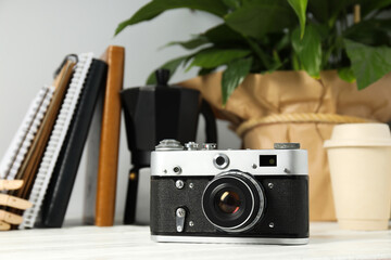 Vintage camera, notebooks and flower on white background, close up