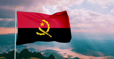 Angola national flag cloth fabric waving on beautiful grey sky Background.