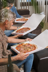 Group of friends eating pizza at home