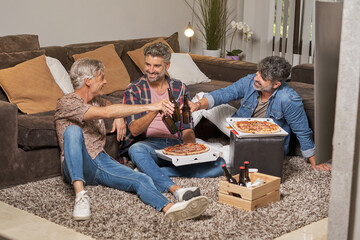 Happy friends toasting beer bottles at weekend party