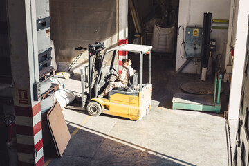 Working woman on a forklift in a warehouse