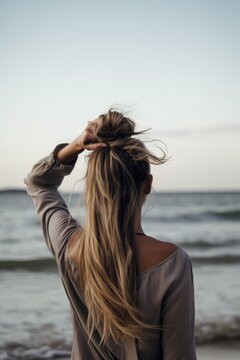 Rearview Shot Of A Woman Holding Her Hair Up By The Sea With Copyspace