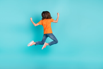 Fototapeta na wymiar Back rear view photo of overjoyed girl wear trendy orange outfit hand fist success sale empty space isolated on cyan color background
