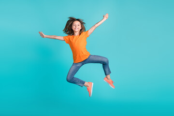 Fototapeta na wymiar Photo of overjoyed cheerful girl wear trendy orange clothes have fun jump up open hnds hug cudle isolated on cyan color background