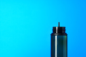 Black electronic cigarettes liquid bottle on blue background
