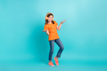 Full length photo of funky cool girl wear trendy clothes listen wireless mp3 player dance have fun isolated on cyan color background