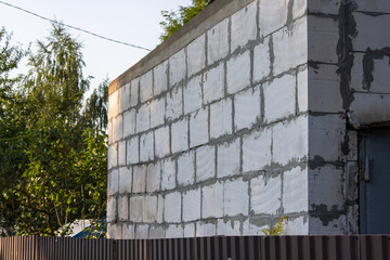 Close-up of a sloppy, crooked and incorrectly built wall of a house made of cellular blocks