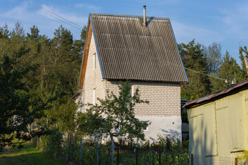 A small tall country house built of brick with a gabled roof of slate