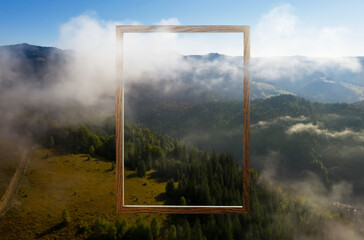 Wooden frame and beautiful mountains with fog in morning