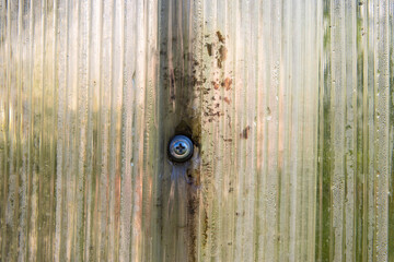 Close-up of incorrect fastening of a polycarbonate sheet with a screw. Damage to polycarbonate in...