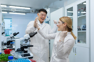 A team of scientists, a young Asian man and woman are working in a laboratory with food products....