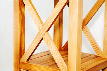 Fragment of a wooden shelving unit with a cruciform design. Carpentry made from natural materials. Close-up. selective focus