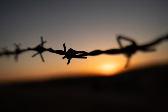 Sunset on the hill behind the barbed wire