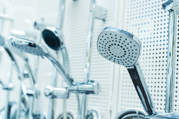 Shower heads trade. Assortment of bathroom equipment on the counter in the store. Foreground