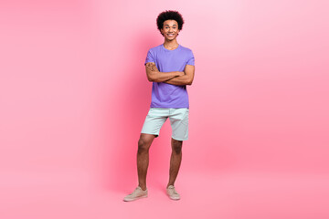 Fototapeta na wymiar Full size photo of positive optimistic guy wear stylish t-shirt white pants standing arms crossed isolated on pink color background