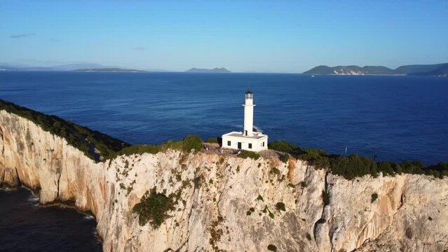 Aerial drone view of the white lighthouse or Cape Ducato Lefkas at sunset in the southern area of Lefkada island. Greece. Rotating pan plane