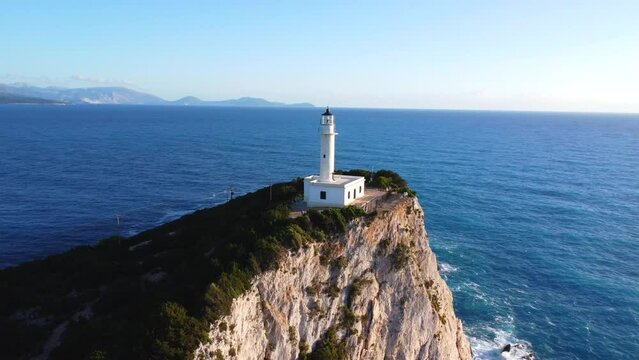 Aerial drone view of the white lighthouse or Cape Ducato Lefkas at sunset in the southern area of Lefkada island. Greece. Rotating pan plane