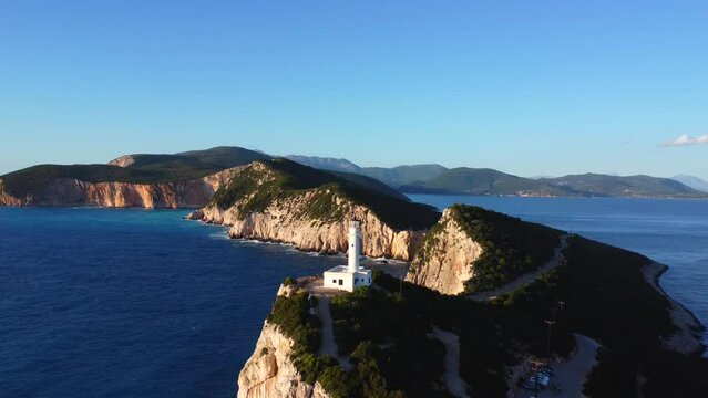 Aerial drone view of the cliffs and the white lighthouse or Cape Ducato Lefkas at sunset in the southern area of Lefkada island. Greece. Zoom plane