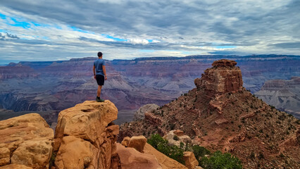 Man with scenic view from Skeleton Point on South Kaibab hiking trail at South Rim, Grand Canyon National Park, Arizona, USA. Colorado River weaving through valleys and rugged terrain. O Neill Butte