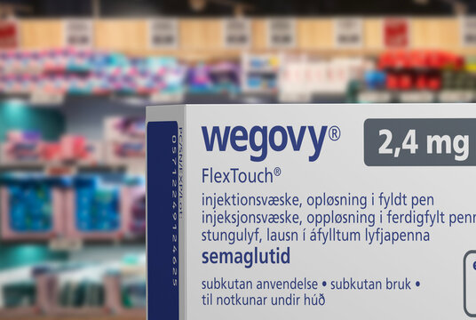 Packaging box of Wegovy (semaglutide) injectable prescription medication, weight-loss drug from Novo Nordisk A/S. Blurred shop shelves in background. Copenhagen, Denmark - August 14, 2023.