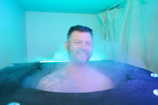 Man sitting in cryobarrel during whole body cryotherapy session