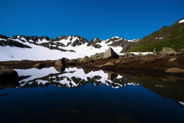 A picturesque lake encircled by rocks, featuring light turquoise and dark green hues, ethereal trees, incredibly beautiful, and meticulously detailed foliage. Generated AI.