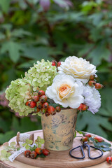 Blumenstrauß mit weißen Rosen, Aster, Hortensienblüten und Hagebutten