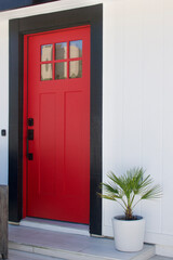 bright red door on a white beach house
