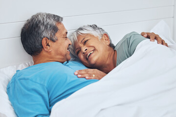 Fototapeta premium Bed, smile and senior couple with love, relax and marriage with retirement, relationship and conversation. Morning, elderly man and old woman with romance, bedroom and trust with peace, home and care