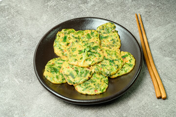 buchujeon, korean Chive Pancake, To prepare this dish, chive, julienned carrot, and green pepper are mixed with flour and pan-fried in a flat, round, pancake-like shape. 