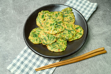 buchujeon, korean Chive Pancake, To prepare this dish, chive, julienned carrot, and green pepper are mixed with flour and pan-fried in a flat, round, pancake-like shape. 