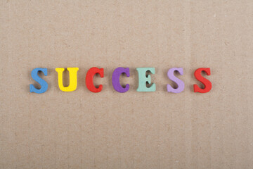 SUCCESS word on wooden background composed from colorful abc alphabet block wooden letters, copy space for ad text. Learning english concept.