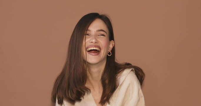 Amazed excited woman hairstyle in beige shirt open face in surprise looking at camera with big eyes, shocked. Indoor studio shot isolated on beige background. Oh my god wow! Wow, it is awesome.