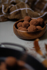 Chocolate truffles covered with cocoa powder. Gray background. Delicious dessert concept. Dark composition.