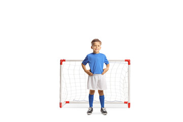 Full length portrait of a boy in a football kit posing in front of a mini goal